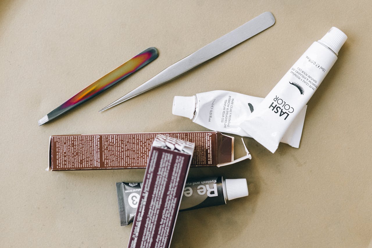 The Art of Drawing Readers In: Your attractive post title goes here Flat lay of eyelash tint and beauty tools on a beige surface, ideal for salon promotions.
